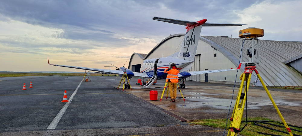 Mesures aéronautiques opérateur réalisant des mesures autour de l'avion, à l'aide d'un théodolite et de cibles entourant l'appareil